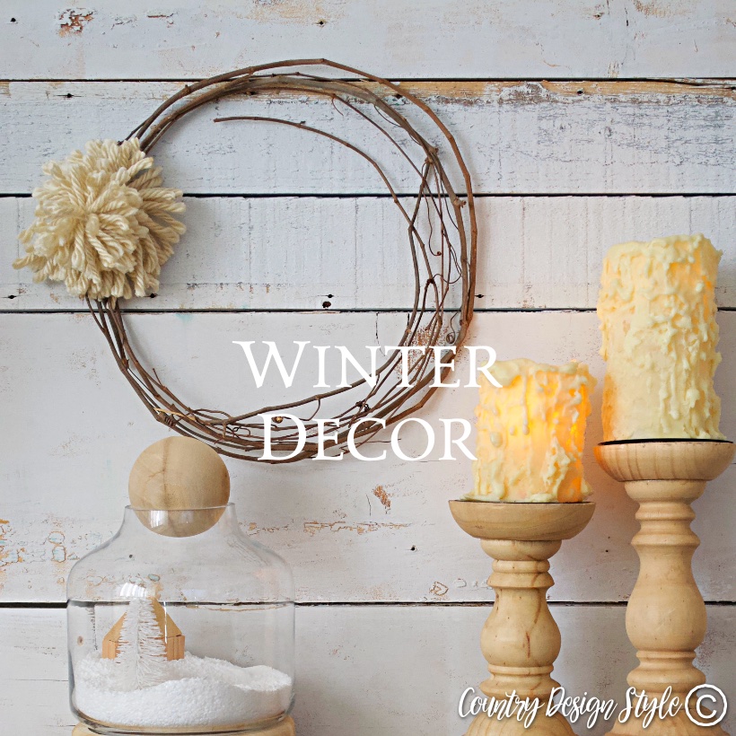 Grapevine wreath with pom pom, candles, and winter scene in a jar.