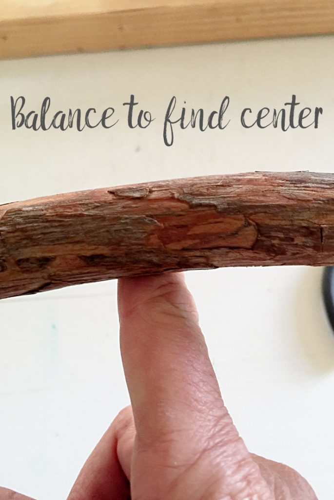 balancing stick on finger to find center.