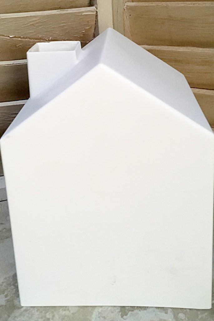plain white plastic tissue box cover in the shape of a house with a chimney. 