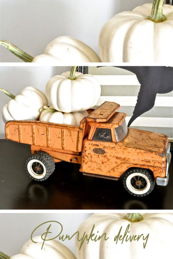 Orange metal toy truck filled with white pumpkins