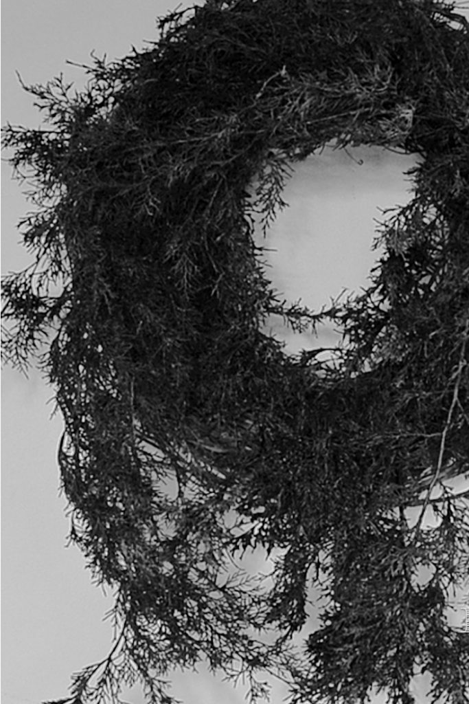 Grapevine wreath with long black pine branches 