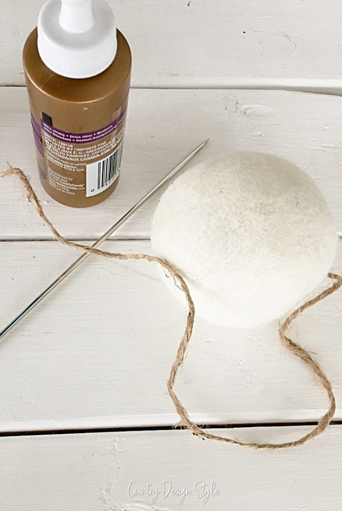 dryer ball with twine, glue and long needle. 