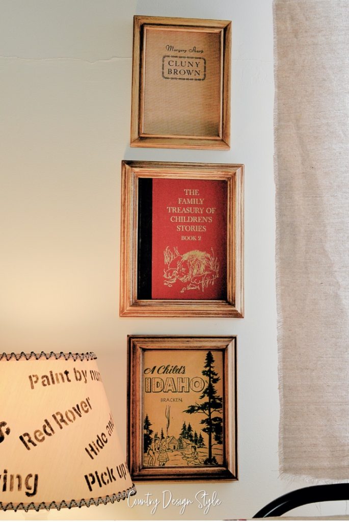 three books in frames hanging